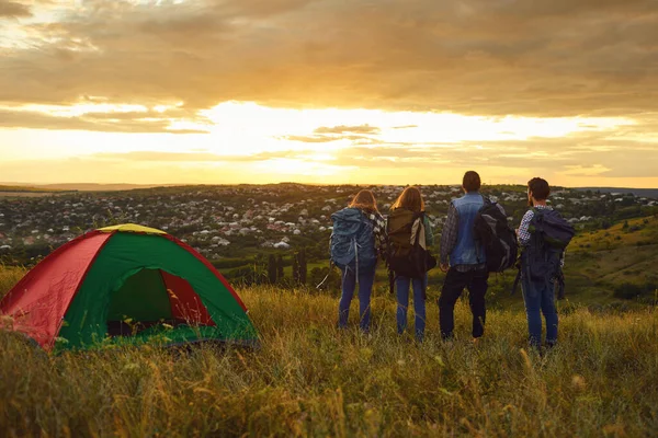 Kempinkový tábor lidé, kteří v přírodě stojí před západem slunce. — Stock fotografie