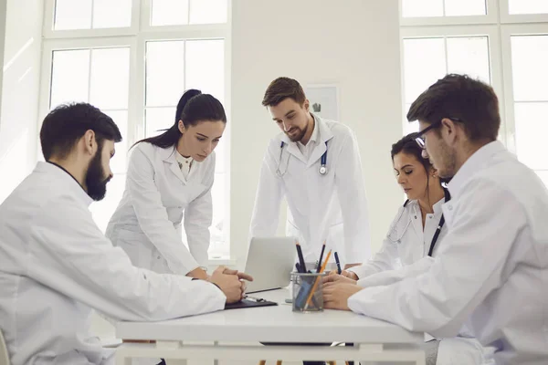 Група лікарів, які розмовляють за столом в офісі лікарні — стокове фото