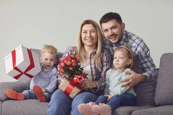 Happy funny family giving presents while sitting on sofa at home. — Φωτογραφία Αρχείου