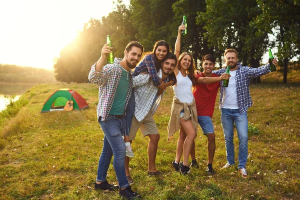 Young people drink and clink glasses at a picnic — Stock Photo, Image