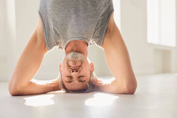 Hombre practicando yoga y de pie en pose de cabecera — Foto de Stock