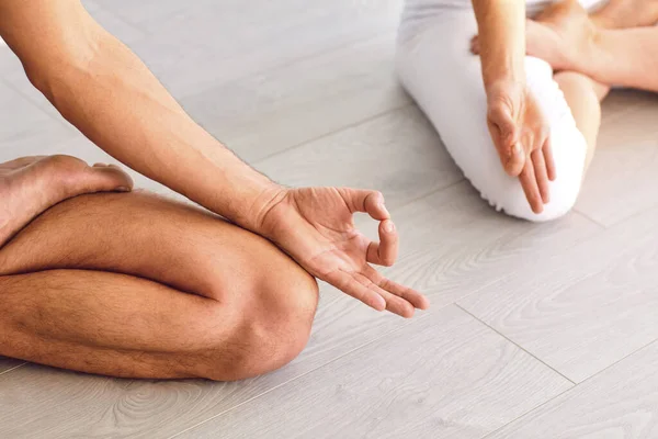 Primer plano de yoga pareja personas mano sentado relajación en el campo de loto en el piso en clase de estudio . — Foto de Stock