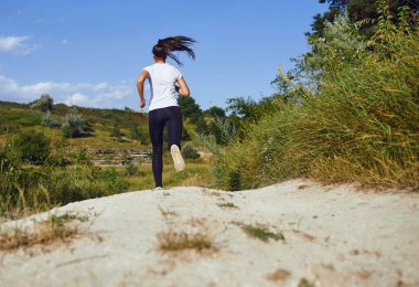 Kız koşucu yazın doğada koşar..