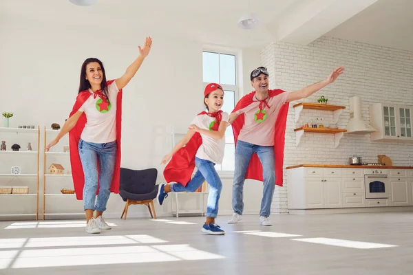 Gelukkige familie in super held kostuums. Grappige familie spelen plezier in de kamer. — Stockfoto