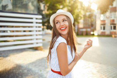 Güzel gülüşü olan bir kız. Şehir sokaklarında gün batımı..