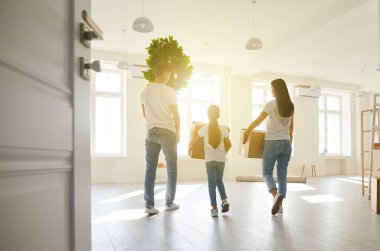 Yeni bir apartmanda kutularla taşınan çocuklu mutlu bir aile. Arka plan.