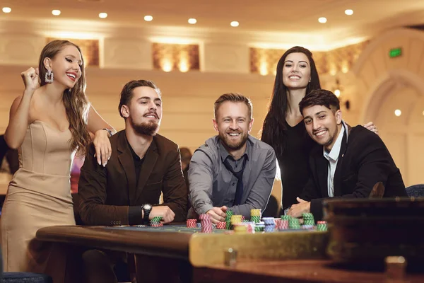 Happy people are betting in gambling at roulette poker in a casino — Stock Photo, Image