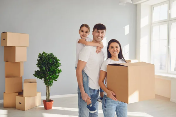 Glückliche Familie mit Kindern zieht mit Kisten in ein neues Mehrfamilienhaus. — Stockfoto
