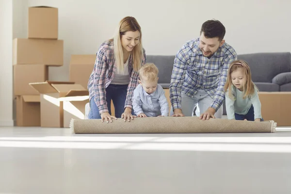 Glad familj med matta på golvet i en ny lägenhet. — Stockfoto