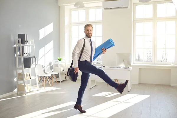 Lustiger Geschäftsmann mit Bart und Yogamatte geht zum Training ins Büro. — Stockfoto