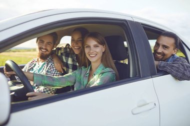 Bir grup mutlu arkadaş arabada araba kullanıyor..