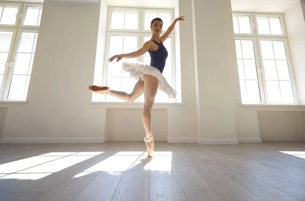 Ballerine. Jeune danseuse de ballet gracieuse répète une performance dans un studio blanc avec fenêtres . — Photo