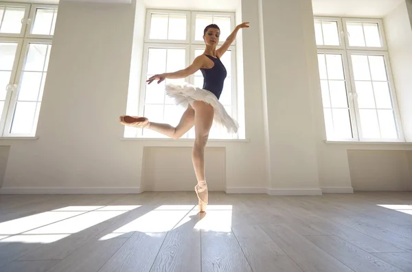 Ballerina. Junge grazile Balletttänzerin probt eine Aufführung in einem weißen Studio mit Fenstern. — Stockfoto