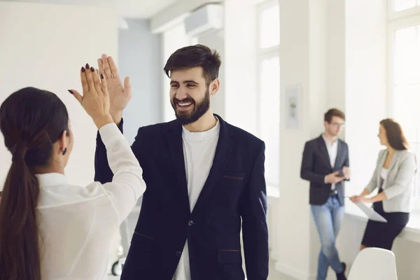 Empresarios trabajadores dan una mano feliz sonriendo proyecto exitoso en el lugar de trabajo en la oficina moderna — Foto de Stock