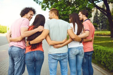 Bir grup insan yazın bir şehir caddesinde kucaklaşır..