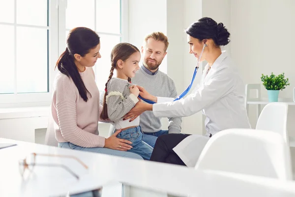 Família feliz em uma visita ao médico no consultório de um médico. — Fotografia de Stock