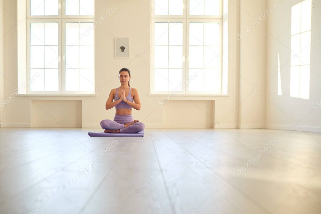 Young woman doing yoga. Beautiful girl resting meditates relax concentrated balance in room.