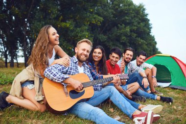 Sonbaharda doğada bir piknik bir gitar ile Arkadaşlar.