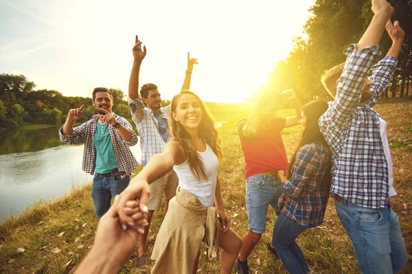 Um grupo de amigos dançando alegremente em uma festa de piquenique na natureza . — Fotografia de Stock