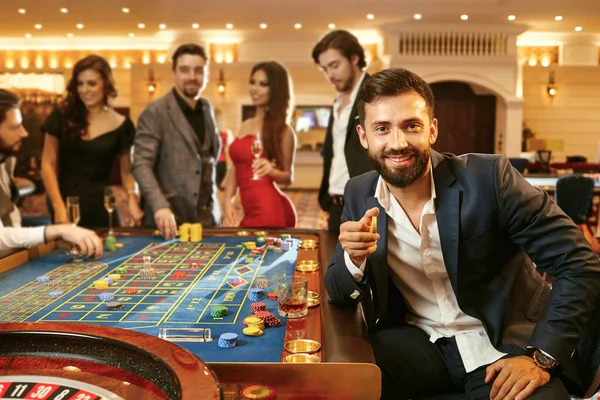 Un homme avec des jetons dans la main jouant au poker à une roulette de poker de casino . — Photo