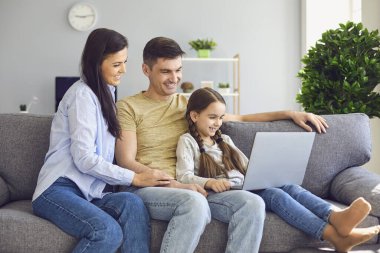 Evde kanepede bebekle otururken internette mutlu bir aile sohbeti..