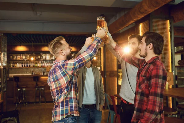 Группа счастливых друзей звонят в бокалы с пивом в спортивном баре . — стоковое фото