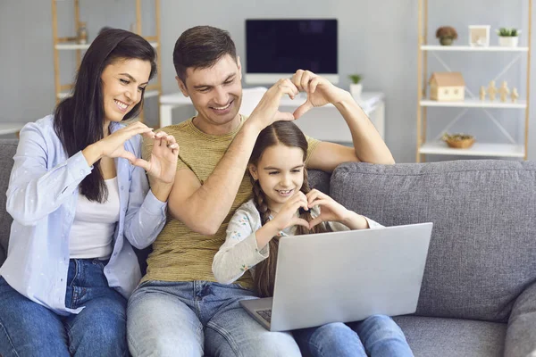 オンラインビデオチャットオンライン。家族は心の形で手を取り合っています自宅でラップトップを使用して手を振って友人を歓迎します. — ストック写真