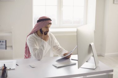 Arap işadamı ofisteki bilgisayarda çalışıyor..