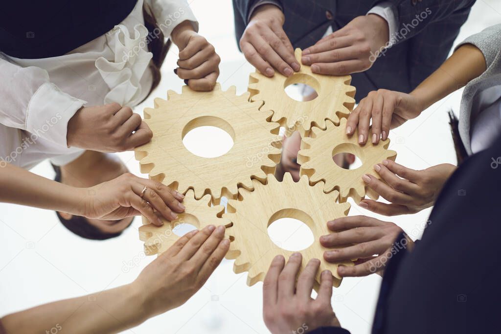 Teamwork concept.Group of businessmen with gears at the table at the workplace in the office.