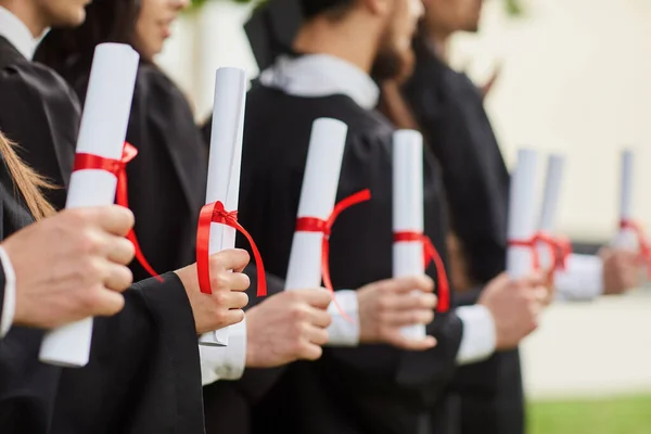 Bir grup mezunun elindeki diploma ların parşömenleri. — Stok fotoğraf