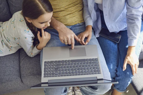 Close-up top view of a happy family using laptop while sitting at home. — Stock Photo, Image