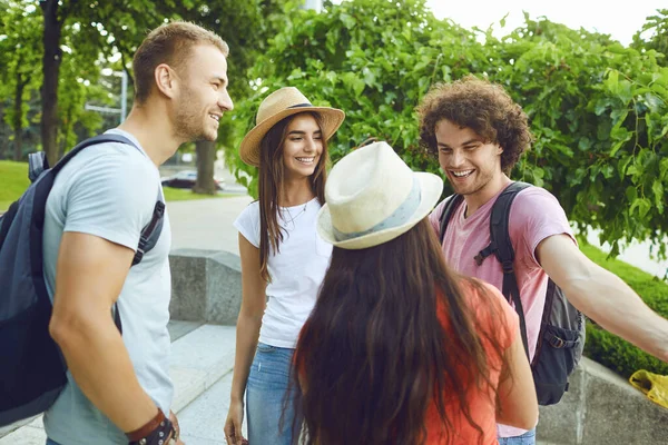Vrolijke studenten glimlachen op een bijeenkomst in een stadspark — Stockfoto