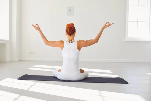 Chica del yoga. Retrospectiva. Chica de fitness está practicando yoga en una posición de loto sentado en un estudio — Foto de Stock