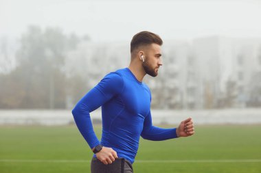 Atletik adam stadyumda antrenman yapıyor..