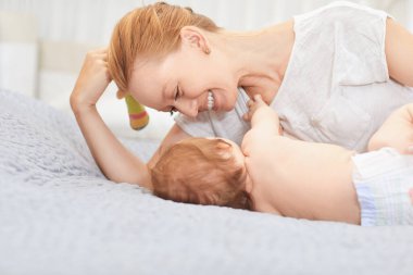 Anne sarılmak onu bebek yalan üzerinde bir yatak