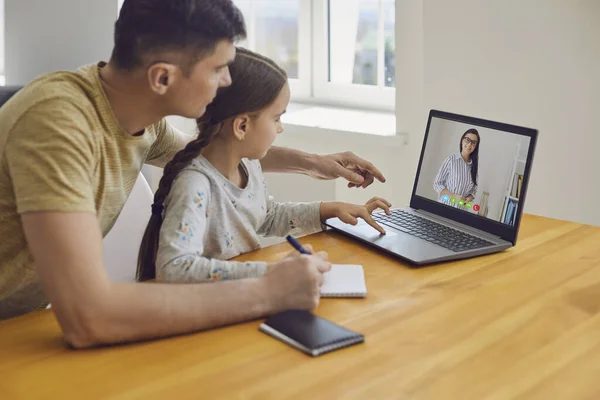 Online-Lernunterricht Bildungsschule. Vater und Tochter machen Online-Unterricht mit einem Lehrer, der zu Hause am Laptop sitzt. — Stockfoto