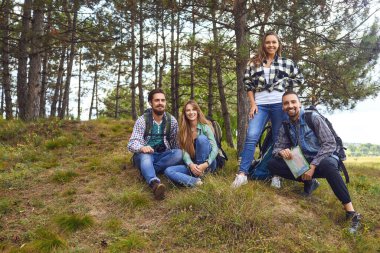 Bir grup turist ormanda otururken dinleniyor.