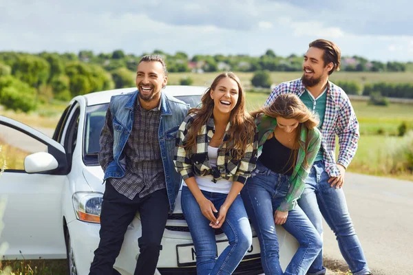 Grupo de personas de pie siguiente viaje en el coche en la carretera . —  Fotos de Stock