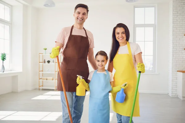 Lycklig familj städar rummet i huset. — Stockfoto