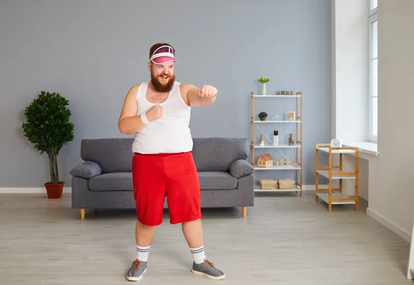 Funny fat boxer in sportswear is boxing in the room. — Stock Photo, Image