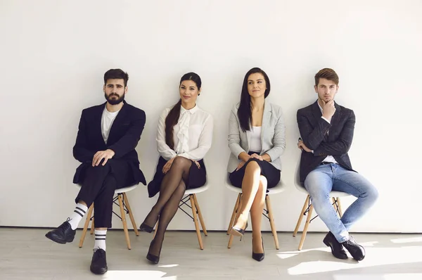 Gente de negocios esperando la contratación de una entrevista de trabajo sentados en una silla en la oficina. — Foto de Stock