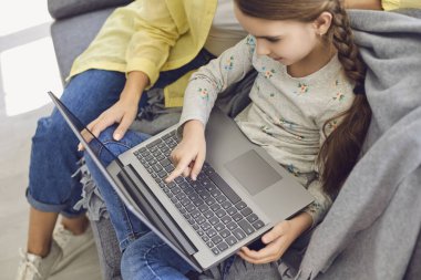Anne ve kızı evde oturup video izleyerek online satın alma eğitimi alıyorlar..