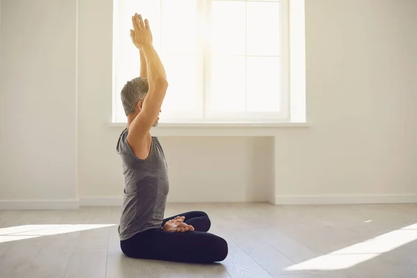 Hombre del yoga. El barbudo está practicando yoga en una posición de loto sentado en un estudio —  Fotos de Stock