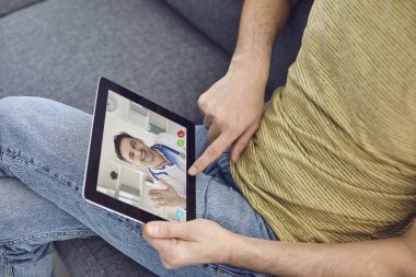 Çevrimiçi doktor. Bir adam doktorla konuşuyor. Uzaktan tıbbi konsültasyon için video çağrı başvurusunu kullanıyor..