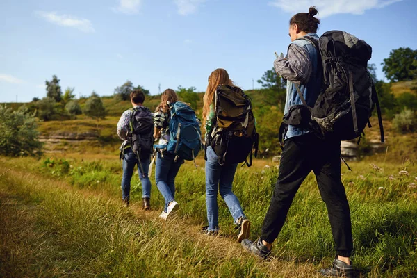 Um grupo de turistas com mochilas está andando na natureza — Fotografia de Stock