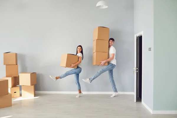 Divertida pareja de mediana edad con cajas de cartón sonriendo en un nuevo apartamento . — Foto de Stock