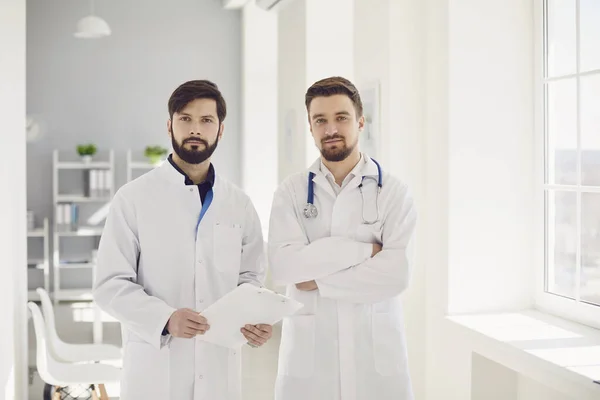 Team praktizierender selbstbewusster Ärzte steht in Klinik. — Stockfoto