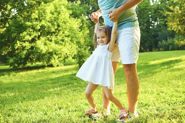 Vatertag. Vater spielt mit seiner Tochter an einem sonnigen Tag auf dem Rasen im Sommerpark. — Stockfoto