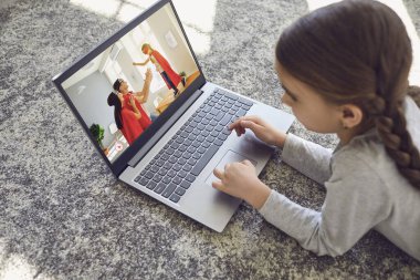 Bir çocuk evdeki videoları izlemek için dizüstü bilgisayar kullanıyor..