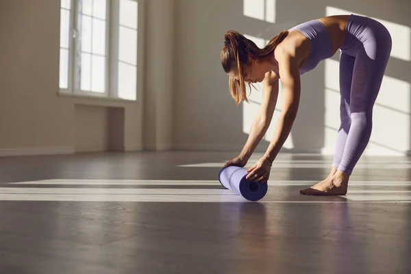 Fitness yoga motion workout kvinna. En kvinna med yogamatta i ett vitt rum i ett ljust rum. — Stockfoto